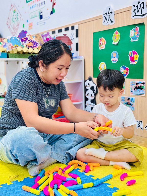 托育服务：老师与幼儿进行回应性互动玩拼插玩具